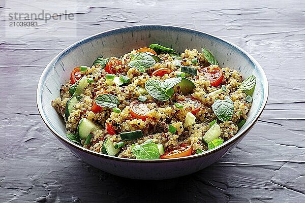 Quinoa tabbouleh salad in a bowl  a healthy dinner with tomatoes and mint on a purple background  Food photography  Food photography