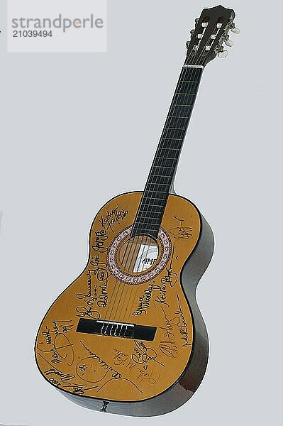 Autographed acoustic guitar on grey background