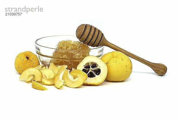 Glass with honey surrounded by vibrant quince fruits  both sliced and whole isolated on white background  full depth of field