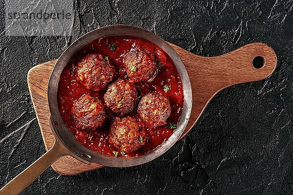 Meatballs. Beef meat balls  overhead flat lay shot in a pan  with parsley and tomato sauce  on a black background  Food photography  Food photography