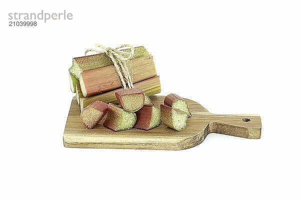 Variety of rhubarb stalks of varying colors from pale green to deep red on wooden cutting board isolated on white background