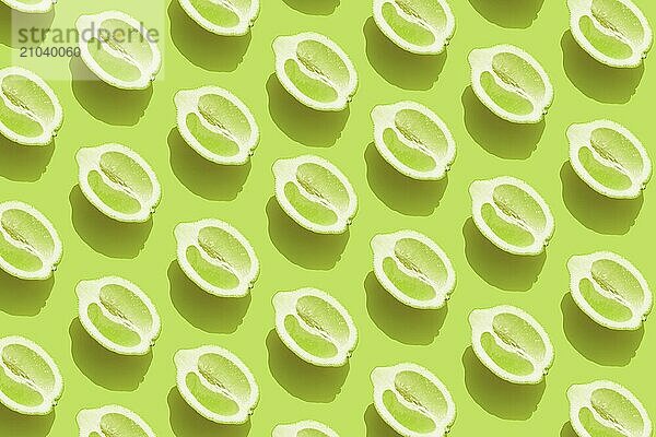 Conceptual pattern with halves of lemon with shadow on green background. Healthy eating  travel or vacation concept