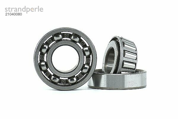 Ball bearings and tapered roller bearing isolated on white background. Spare parts for machinery and automotive industry