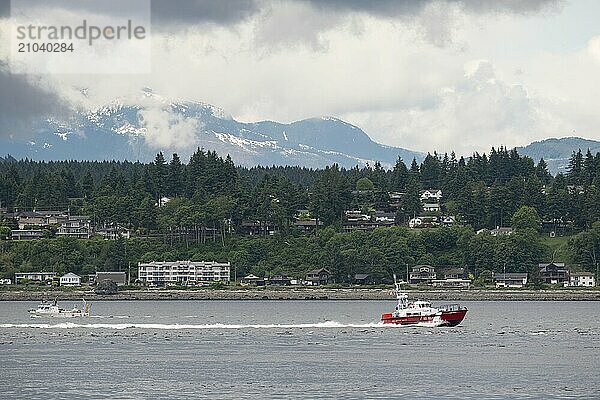 The Canadian Coast Guard sails off the east coast of Vancouver Island  past the village of Campbell River