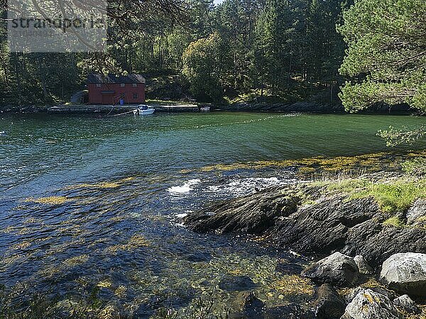 A motorboat lies in front of a house on the Björnafjord in Norway