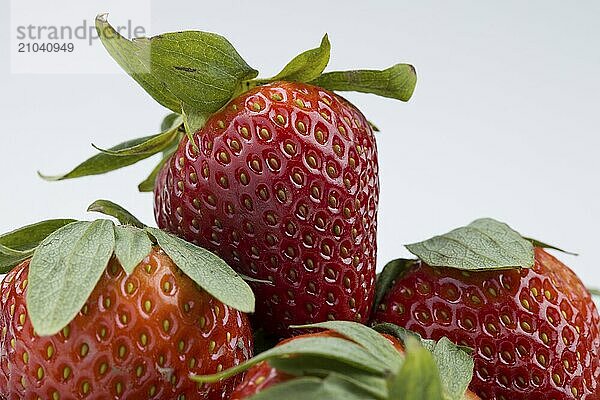 A macro close up photo of ripe red straberries with a white background