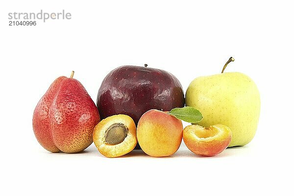 Whole and halved ripe apricots  multicolored pear  red and green apples isolated on a white background. Multivitamin and juicy rich fruit