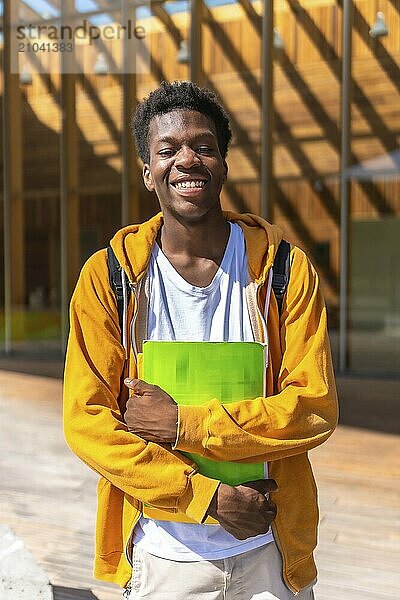 Vertical portrait of a confident and smiling african american student outside the university