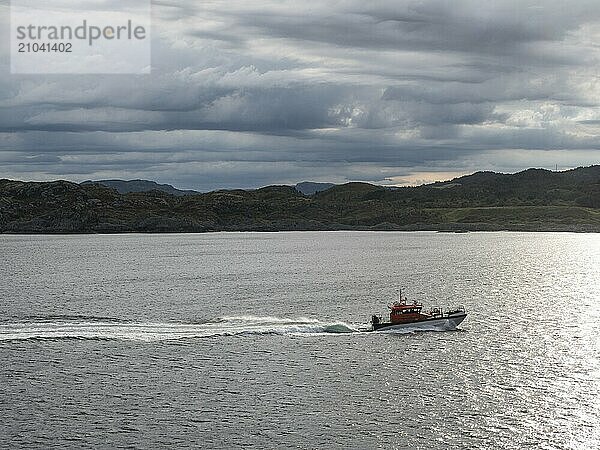 A pilot boat sails along the Norwegian coast