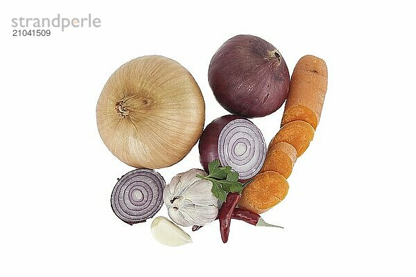 Top view of vegetables consisting red and yellow onions  red chili peppers  bulb of garlic and sliced carrots isolated on a white background