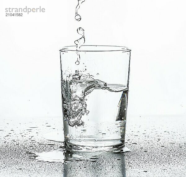 Water being poured into a glass. White background