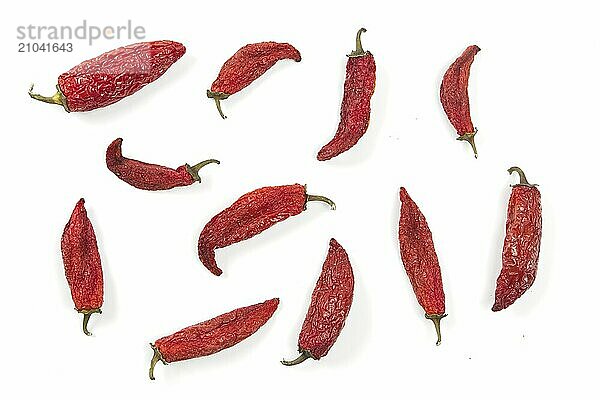 A flat lay studio photo of partially drying red peppers set on a white background