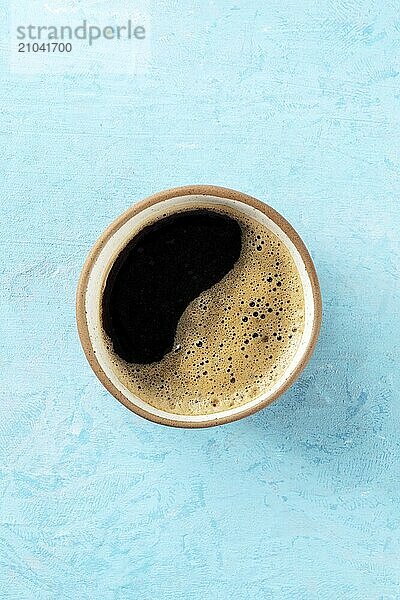 Coffee cup  top shot on a blue background with copy space  espresso drink