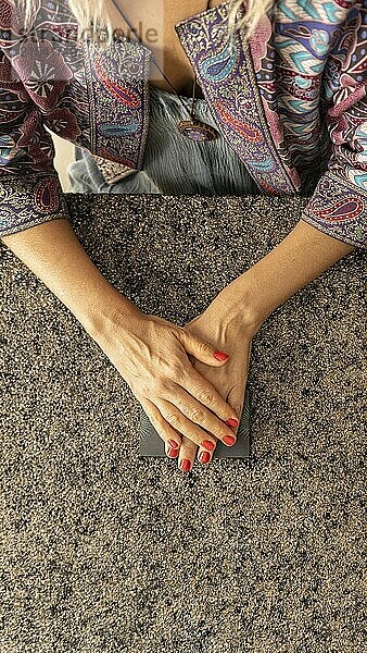 Top view of a tarot reader's hands over the tarot deck