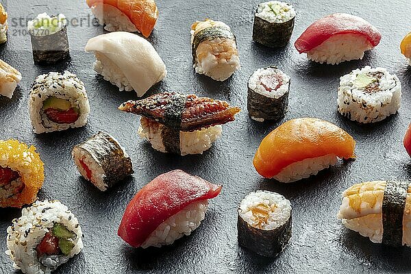 Sushi assortment. Rolls  maki  nigiri on a black background  Japanese food. Salmon  tuna  eel  shrimp with rice on a plate at an Asian restaurant