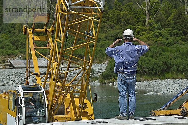 Builders construct a concrete bridge over a small river in Westland  New Zealand  Oceania