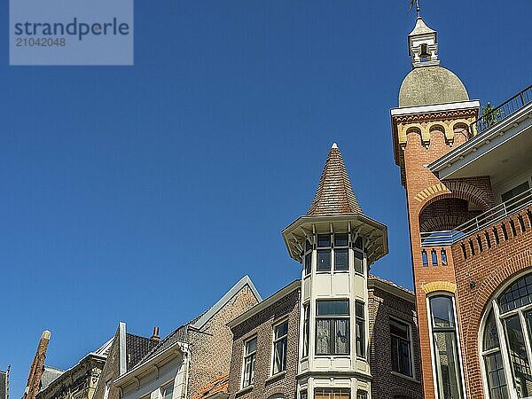 Row of buildings with detailed brick roofs and towers against a clear sky  alkmaar  the netherlands