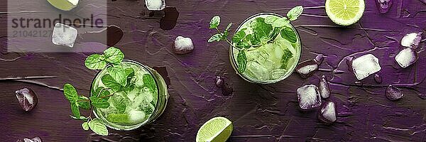 Mojito cocktail panorama. Summer cold drink with lime  fresh mint  and ice. Cool beverage on a purple background  top shot  Food photography  Food photography