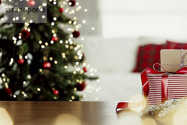 Christmas  New Year background with copy space for design. Empty wooden tabletop surface  blurred Christmas fir tree composition  bokeh sparkle lights effect. Mockup ready for product montage