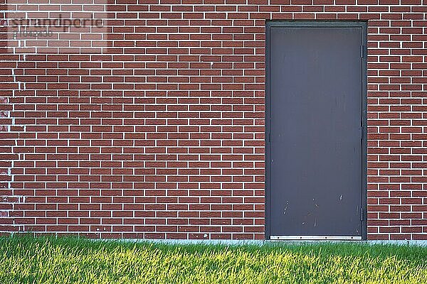 Brick wall with rectangular door and a meadow in front of it  Ontario  Canada  North America