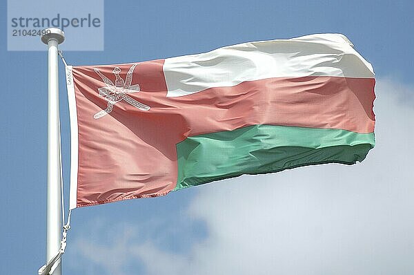 The flag of Oman against blue sky