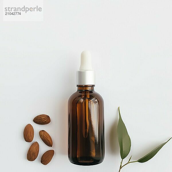 Almond essential oil in glass bottle with green leaf. Cosmetic concept on white background  isolated flat lay.