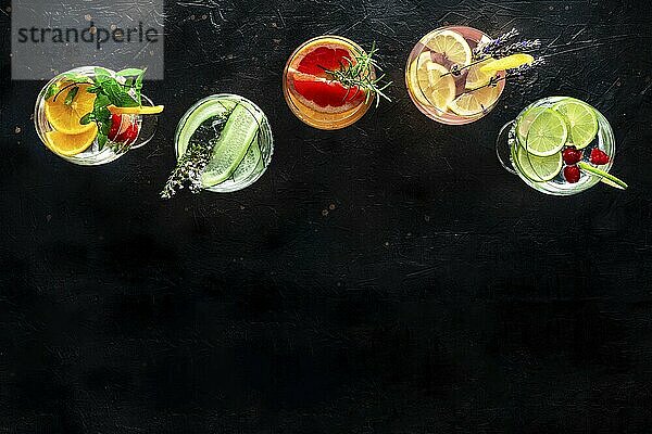 Fancy cocktails with fresh fruit. Gin and tonic drinks with ice at a party  on a black background  shot from above with a place for text  Food photography  Food photography