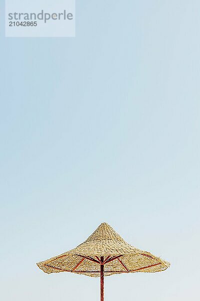 Looking up at wooden straw umbrella or thatched hut from below against beautiful cloudy blue sky view on tropical Egypt beach. Summer or winter holiday concept. Egyptian resort.