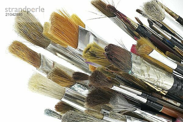 Paintbrushes varying sizes and bristle styles include flat to round and others with wooden handles isolated on white background