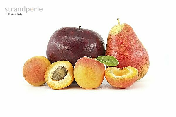 Assortment of fresh healthy fruits including whole and halved ripe apricots  pear and apple isolated on a white background. Multivitamin and juicy rich fruits