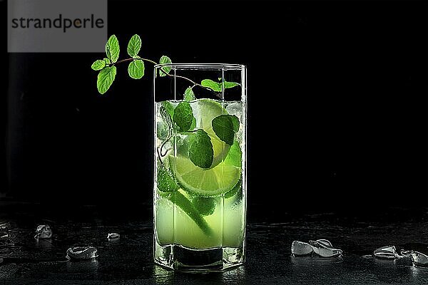 Mojito cocktail. Summer cold drink with lime  fresh mint leaves  and ice. Cool beverage on a black background  Food photography