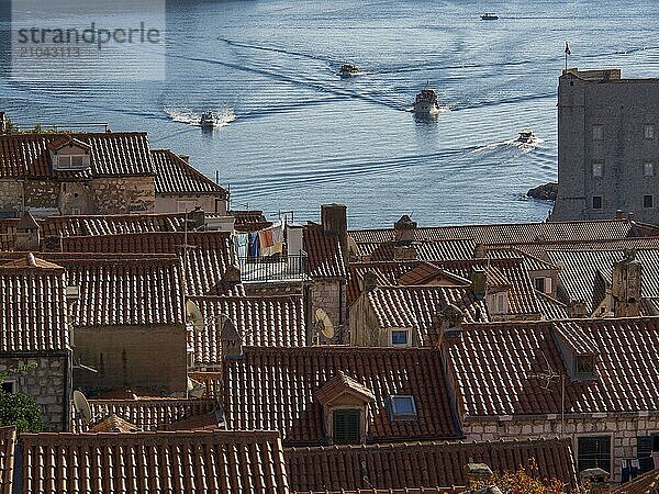 Overview of an old town  red roofs and boats crossing the calm water  dubrovnik  Mediterranean Sea  Croatia  Europe