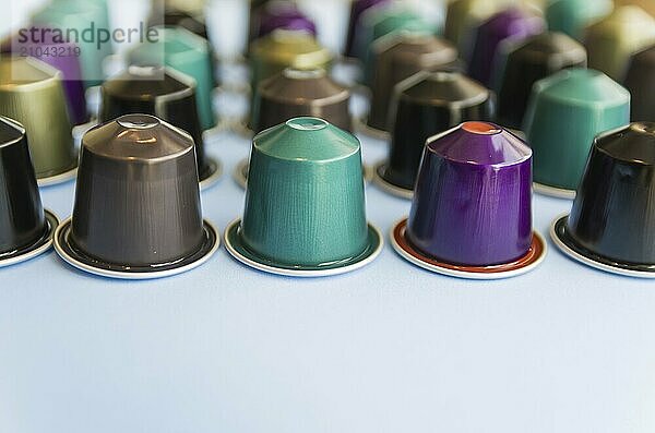 Beautiful colored coffee capsules on light blue background