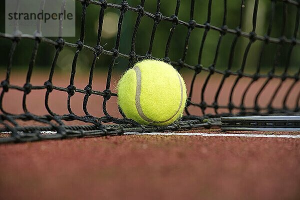 Tennis scene with black net  ball on white line in low angle view