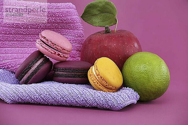 Group of colorful macarons and fruits over pink background. Full depth of field