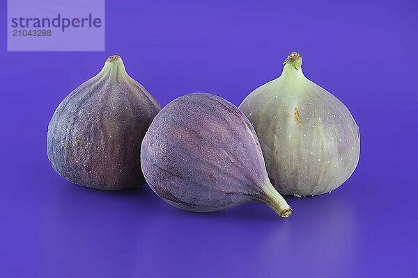 Pile of fresh figs over purple background. Full depth of field