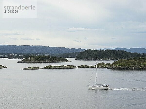 A sailing yacht cruises through the Norwegian archipelago