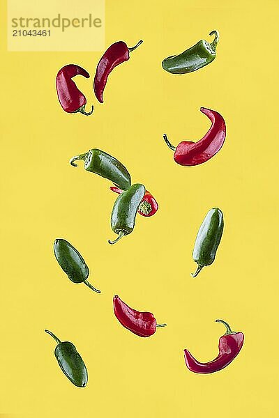 Red and green jalapeno peppers set against a yellow background