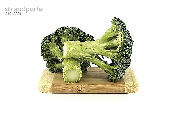 Raw broccoli on bamboo cutting board isolated on white background  full depth of field