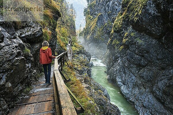 The River Lammer in the Lammerklamm gorge. A hiker on her way through the gorge. Autumn. Scheffau  Lammertal  Salzburger Land  Upper Austria  Austria  Europe