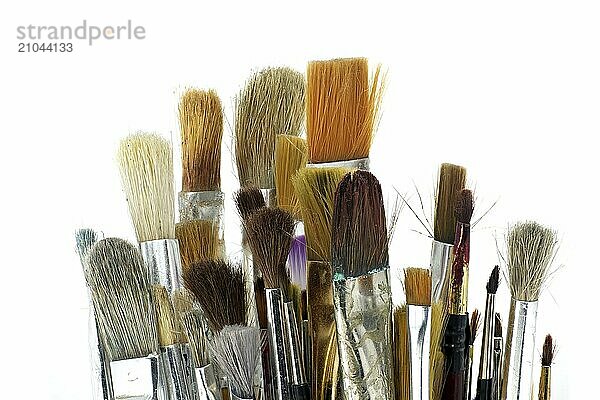 Paintbrushes varying sizes and bristle styles include flat to round and others with wooden handles isolated on white background