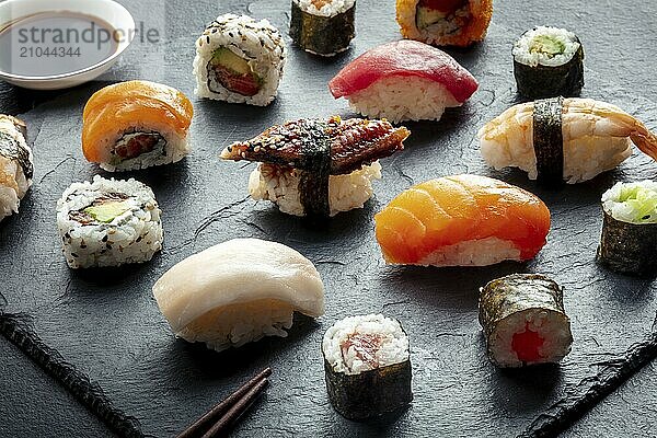 Sushi with soy sauce. Rolls  maki  nigiri on a black background  Japanese food. Salmon  tuna  eel  shrimp and other seafood with rice on a plate at an Asian restaurant  Food photography  Food photography