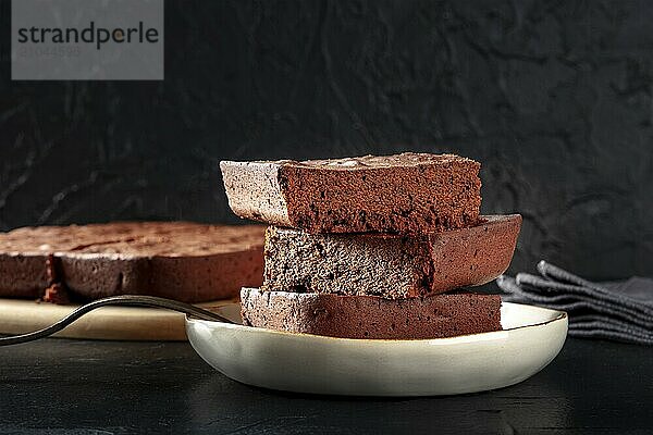 Chocolate brownie  simple coffee cake  a side view on a black background with a place for text  Food photography