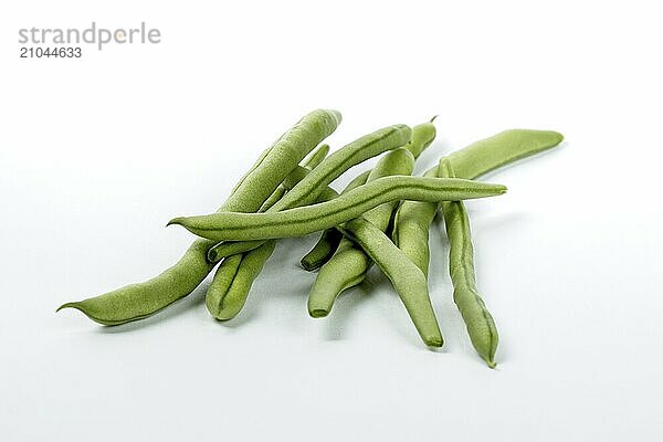 A close up photo of freshly harvested raw green beans on a white background