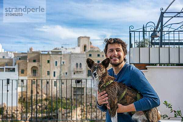 Man with brown dog looking and smiling at the camera