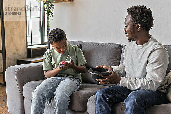 African American father and boy having fun playing charades game