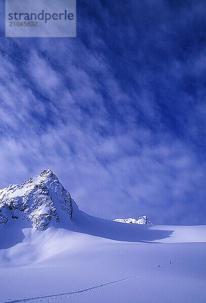 A man and woman ski tour and explore the mountains of the Lyngen Alps in Norway.