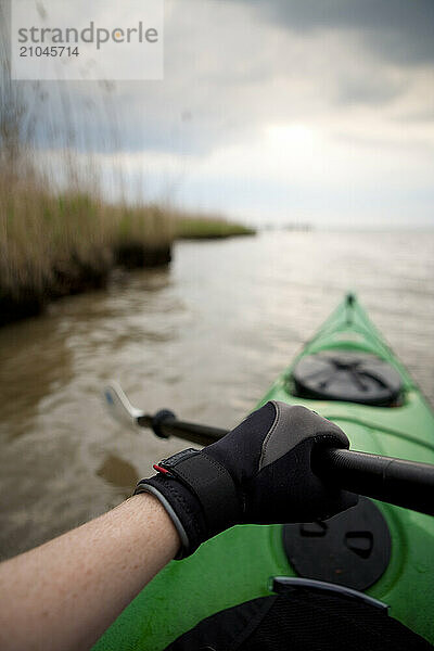 Sea kayaker paddling along the shoreline of the Chesapeake Bay on the Virginia side of the Potomac River.