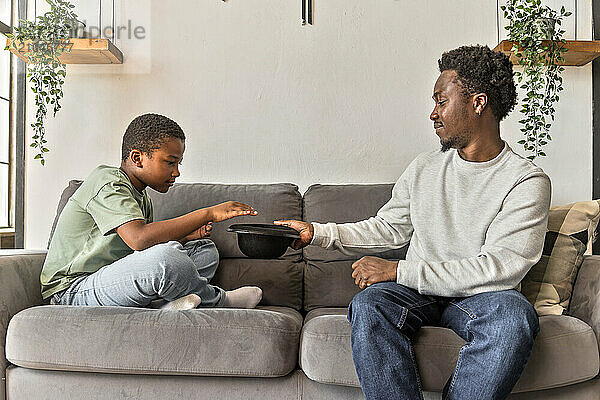 African American father and boy having fun playing charades game