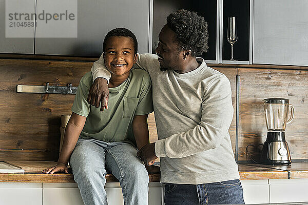 African American father and boy having fun and laughing in kitchen